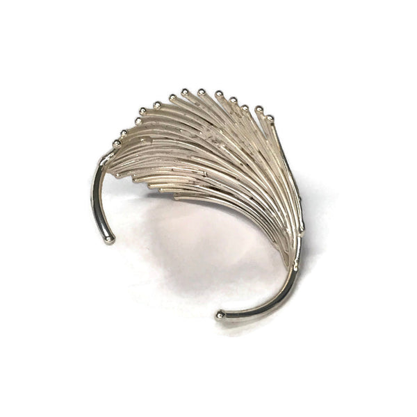 bracelet en laiton argenté, assemblage serré de petites baguettes de métal en forme d'éventail, sur environ 3,5 cm de large, vue de dos