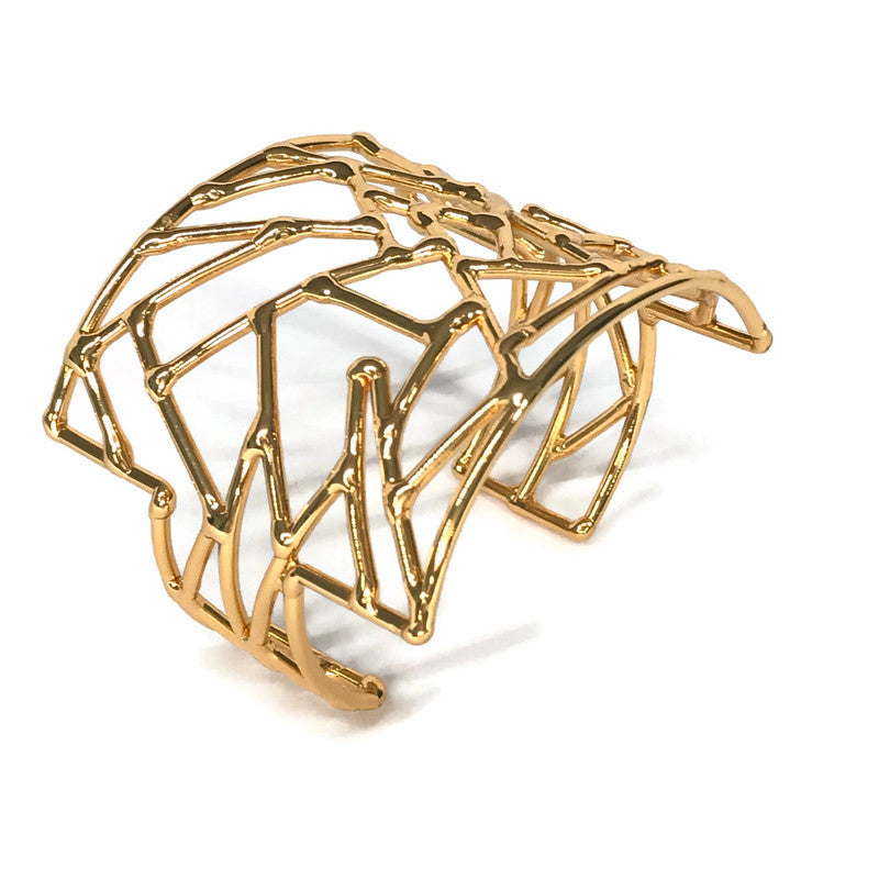 bracelet manchette de créateur, doré, motif composé de formes irrégulières telle une mosaïque, ajustable au poignet, vue de dessus