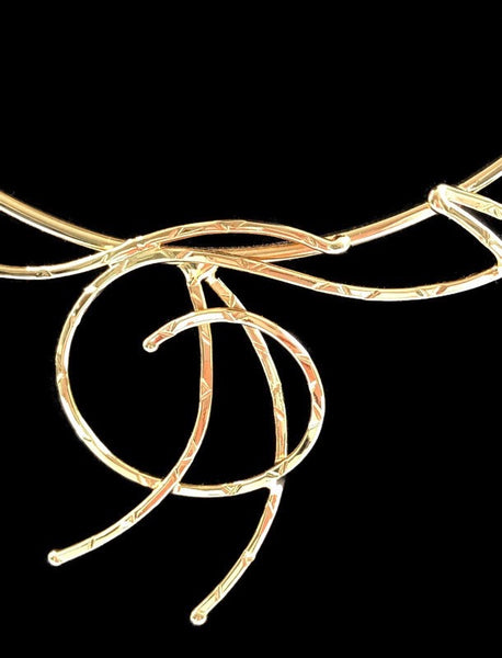 collier martelé ; boucles et méandres en laiton doré ; détail du motif au centre