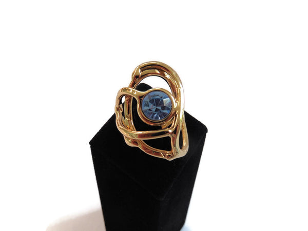 bague en laiton doré avec strass au centre, 2,5 cm de large environ, formée d'entrelacs courbés, vue zoomée