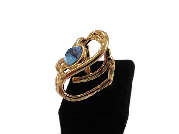 bague en laiton doré avec strass au centre, 2,5 cm de large environ, formée d'entrelacs courbés, vue de côté