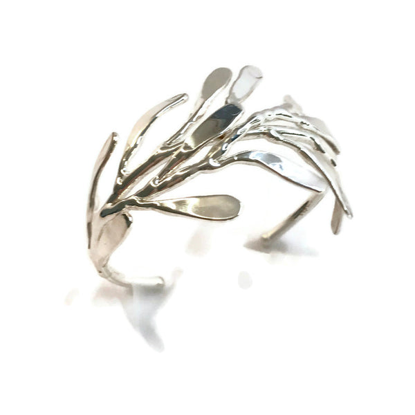 bracelet de créateur, argenté, motif végétal, petites feuilles assemblées qui capte la lumière, vue de dessus