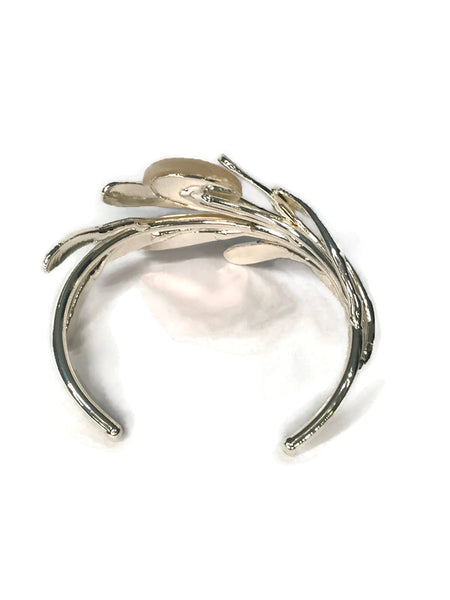 bracelet de créateur, argenté, motif végétal, petites feuilles assemblées qui capte la lumière, cabochon de nacre au centre,vue de dos