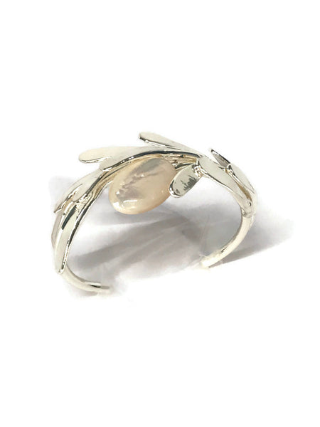 bracelet de créateur, argenté, motif végétal, petites feuilles assemblées qui capte la lumière, cabochon de nacre au centre,vue de dessus