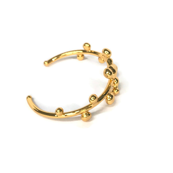 bracelet jonc orné de petites boules de métal fondu sur le pourtour, doré, vue de biais