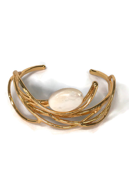 bracelet en laiton doré, courbes de métal enserrant une nacre véritable, sur environ 2,5 cm de large, zoom sur la nacre