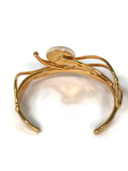 bracelet en laiton doré, courbes de métal enserrant une nacre véritable, sur environ 2,5 cm de large, vue de dos