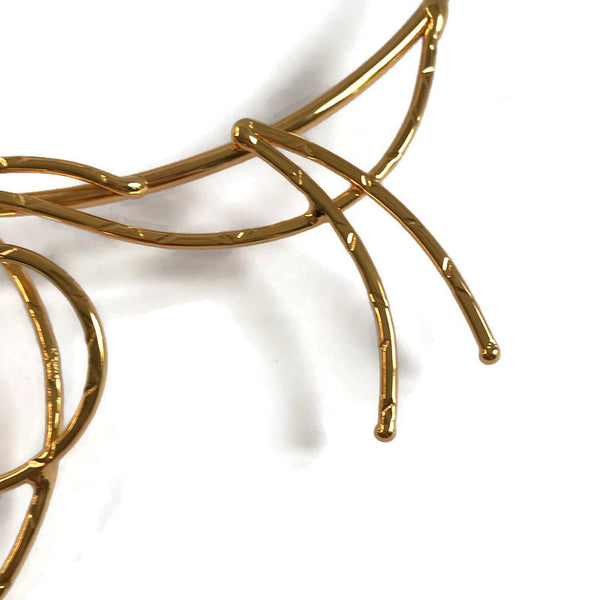 collier martelé ; boucles et méandres en laiton doré ; détail du motif sur le côté