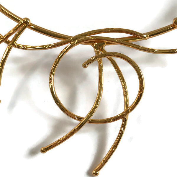 collier martelé ; boucles et méandres en laiton doré ; détail du motif au centre