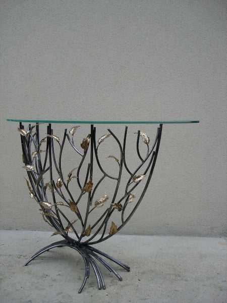 console en forme de demi-lune, plateau de verre porté par un entrelacs de tiges d'acier ornées de feuilles en laiton, vue de côté