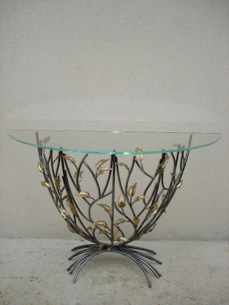 console en forme de demi-lune, plateau de verre porté par un entrelacs de tiges d'acier ornées de feuilles en laiton, vue de face