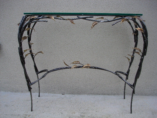 console rectangulaire, plateau de verre porté par un entrelacs de tiges d'acier ornées de feuilles en laiton, vue rapprochée