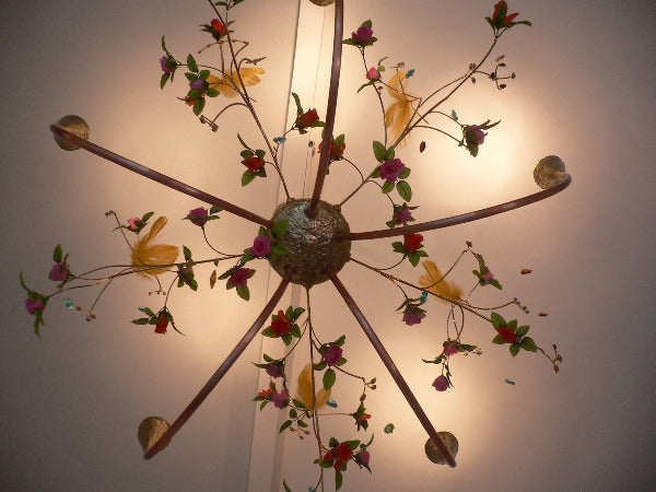 lustre composé de 5 branches en cuivre ornées de pampilles, fleurs en tissu, plumes ; lampes dichroides, avec fines branches de laiton en volutes, vue de dessous