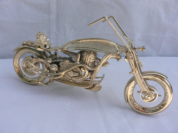 moto chopper composée de pièces de ferronerie antiques, laiton et cuivre flashés or, vue de biais